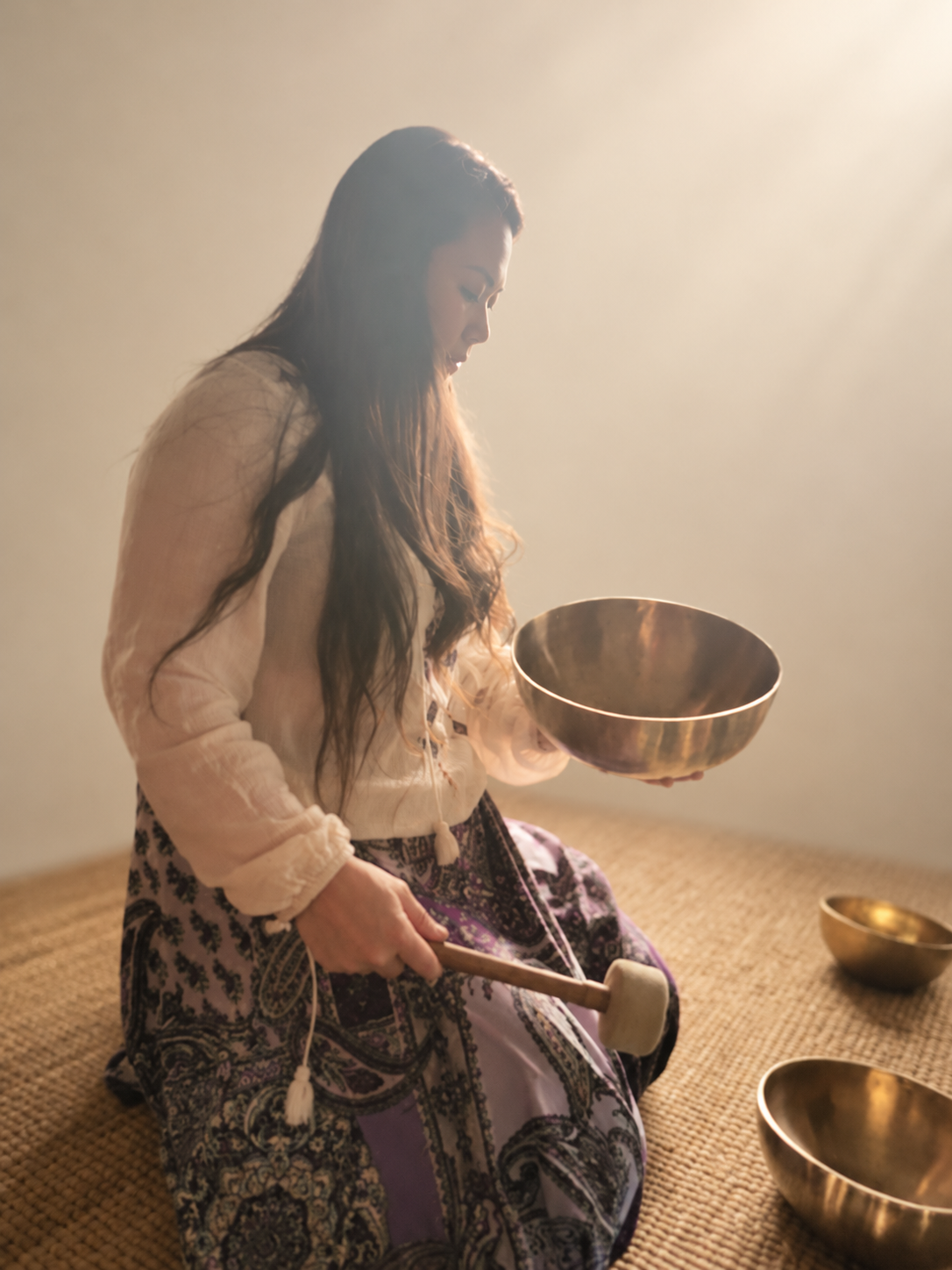 Fan holding a singing bowl in soft natural light